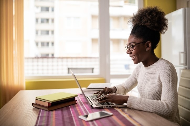 Young Woman sitting at home using laptop and studying
