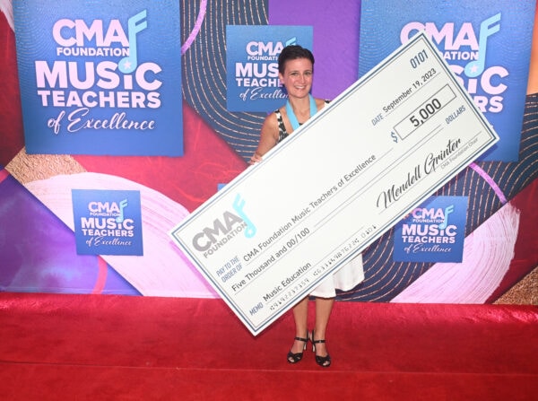 CMA Foundation 2023 Music Teacher of Excellence Shawna Longo holding a big check for $5000