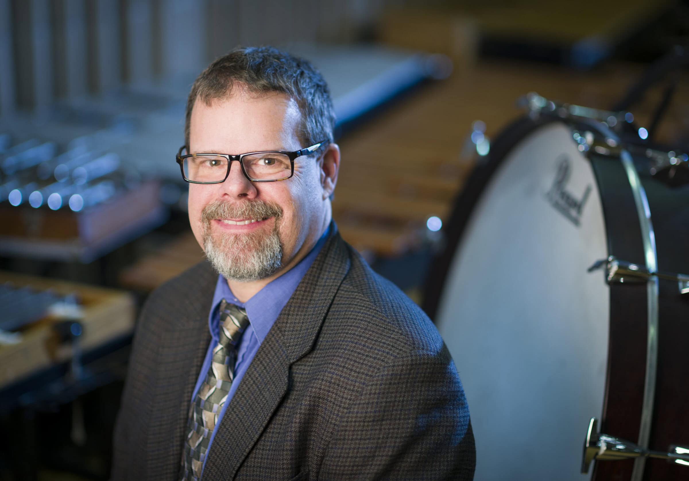 Chris Johnson headshot of Christopher Johnson with band instruments in the background