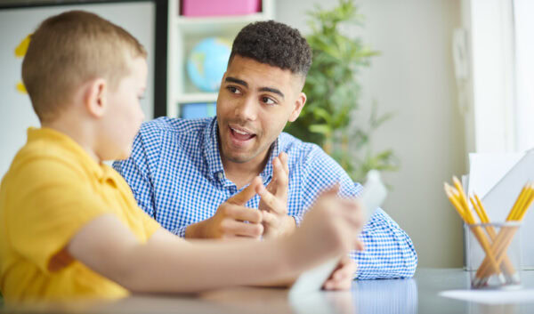 male teacher in conversation with elementary school student