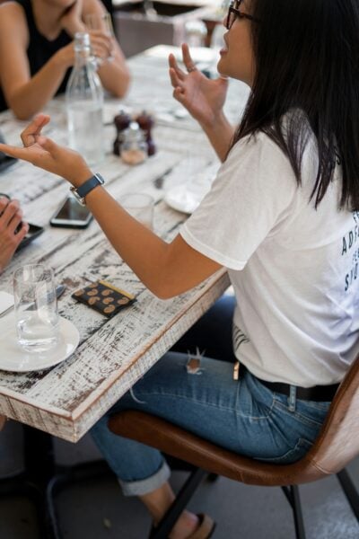 closeup photo of woman in conversation with others at a table