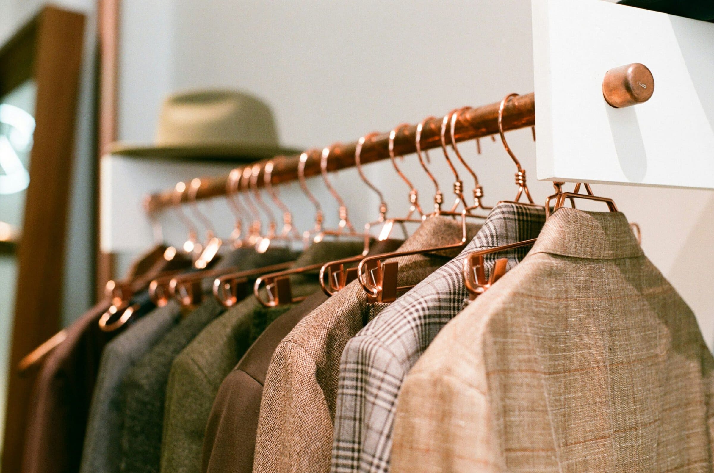 detail of tailored suit jackets hung on a rack